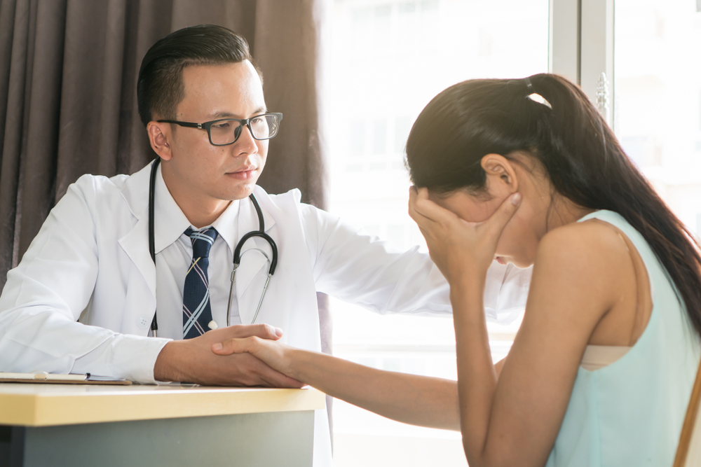 stressed girl being comforted by doctor