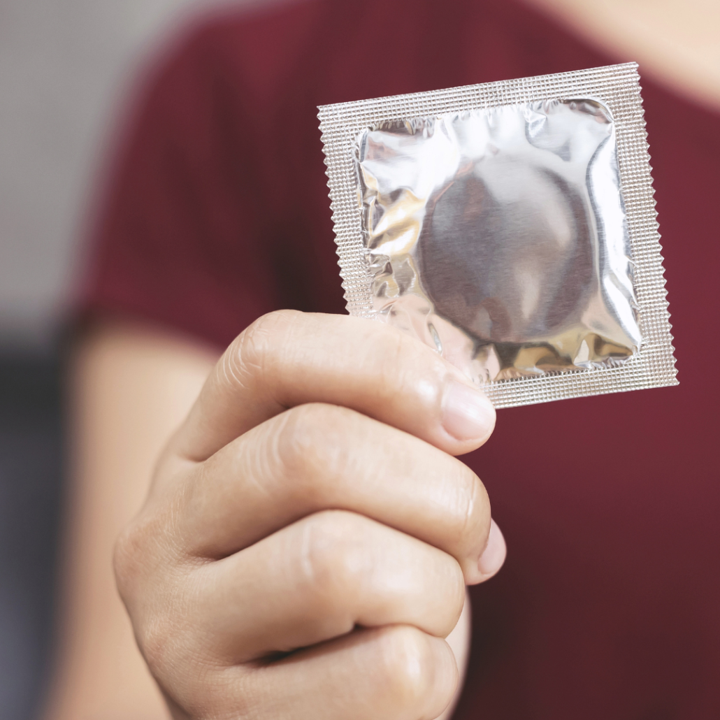 a woman holding a condom in her hand as a birth control option